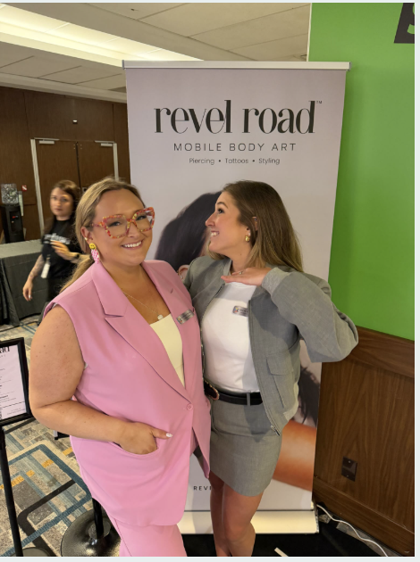 Founders posing together in front of the Revel Road banner at an event