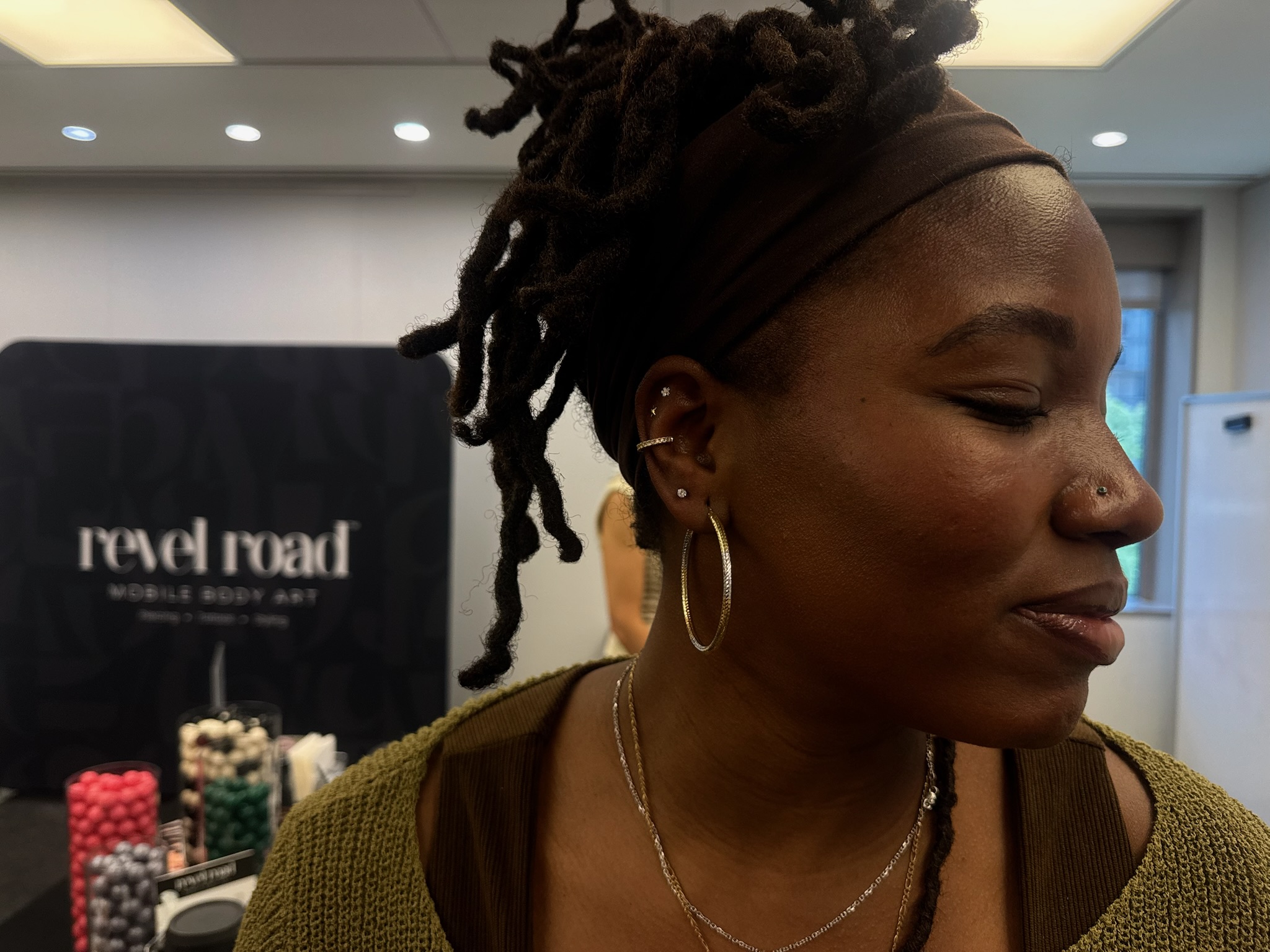Guest's curated ear stack with hoops and studs in profile
