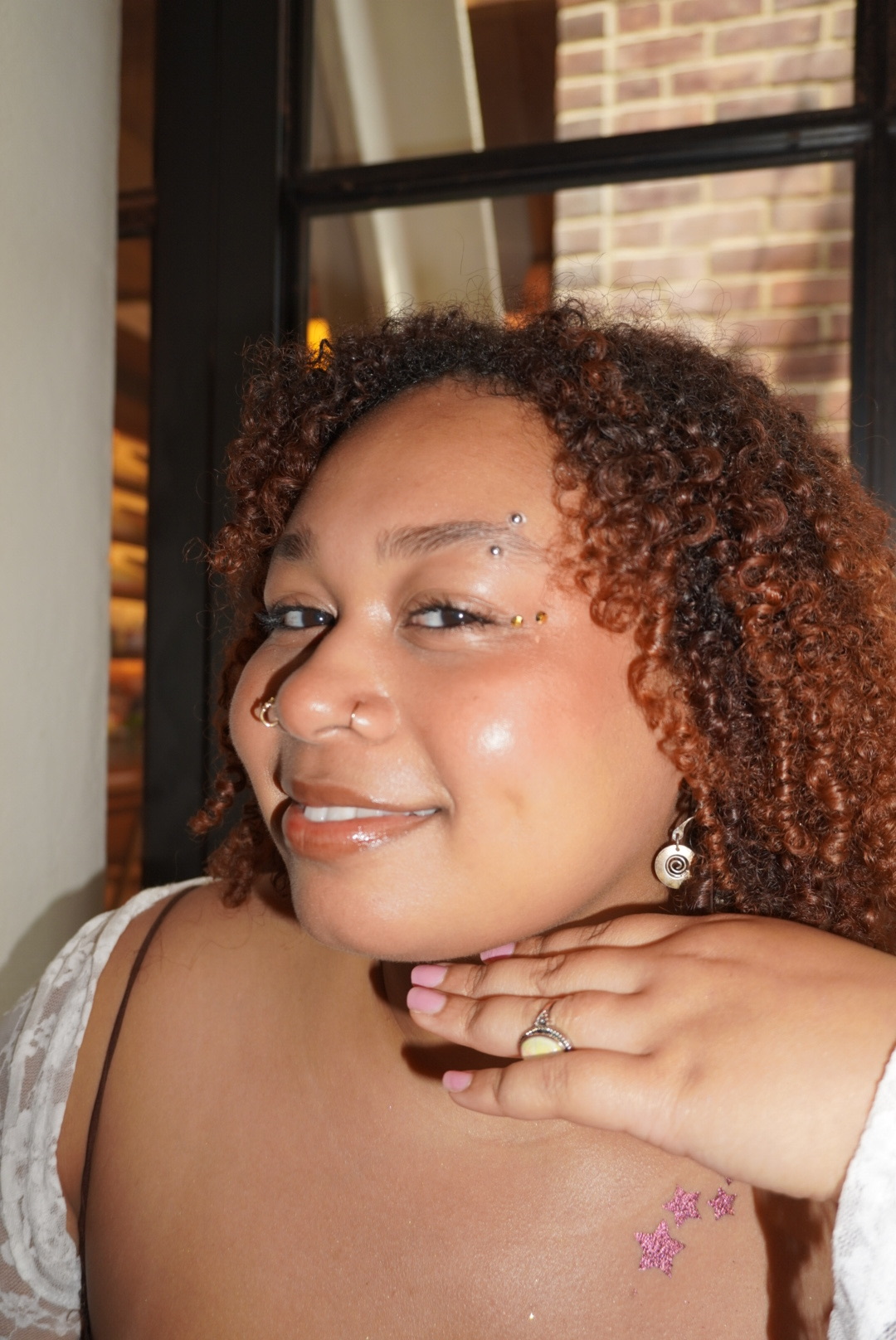 Guest with glitter star body art and face gems at an event