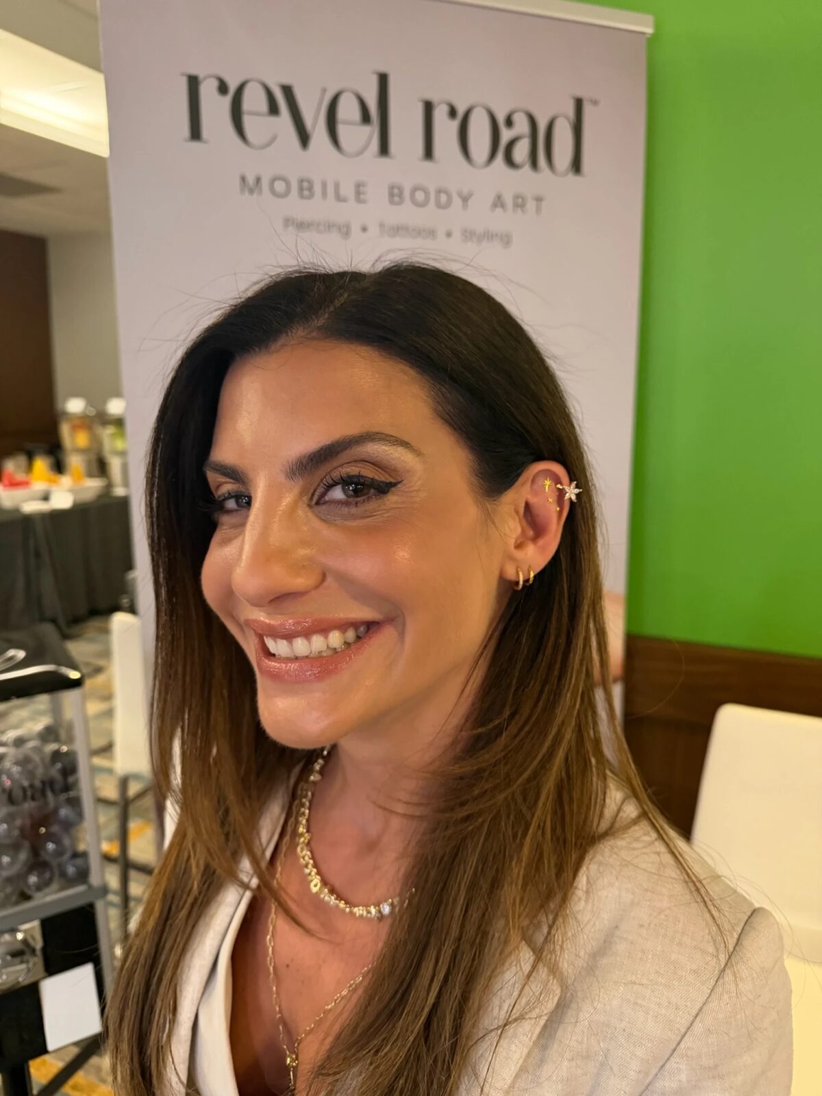 Attendee smiling with a gold Revelmarks ear stack at CommerceNext