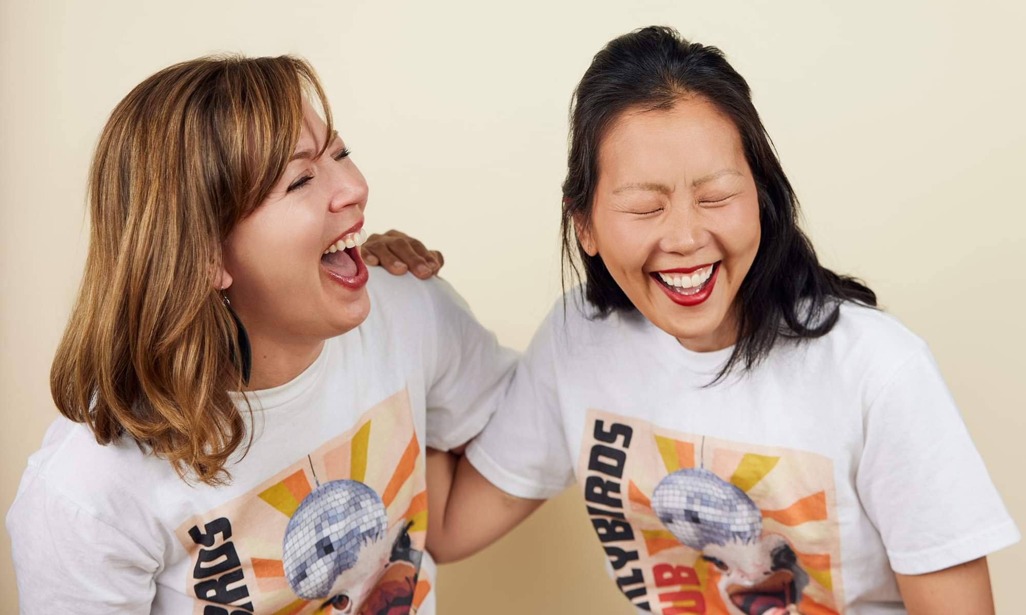 Earlybirds Club co-founders Laura and Susie laughing together in Earlybirds t-shirts