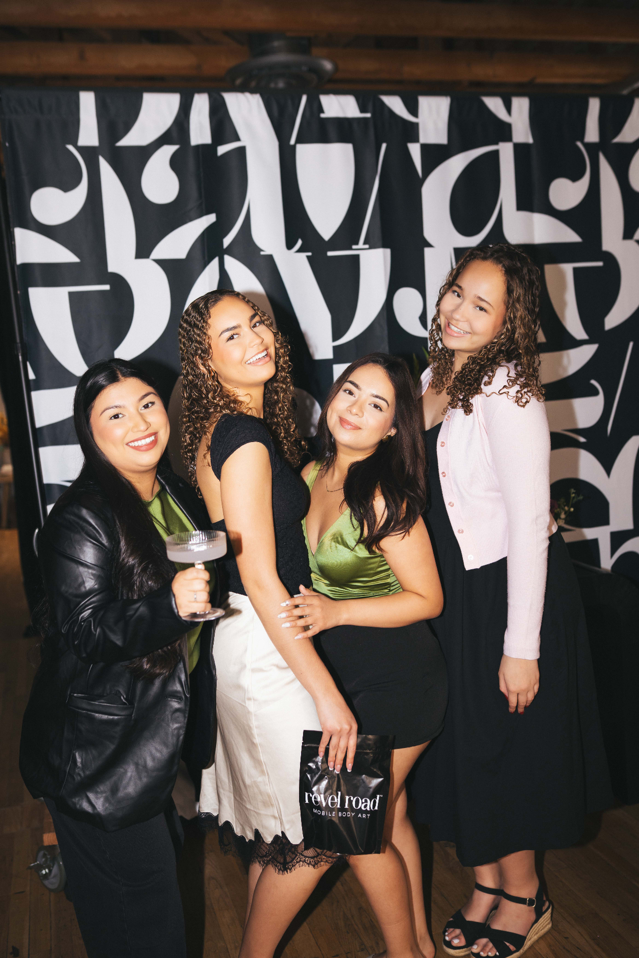 Guests posing with a Revel Road pouch at an event