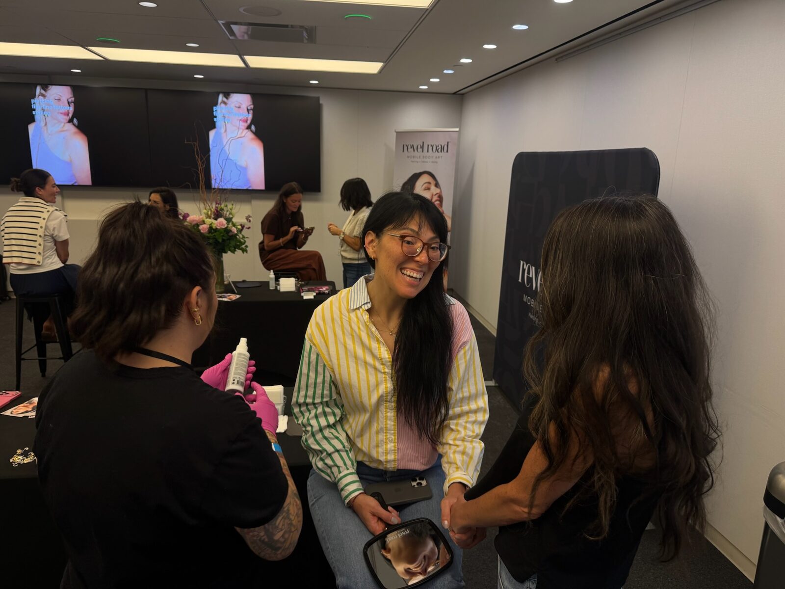 Guest smiling at the Revel Road booth during styling